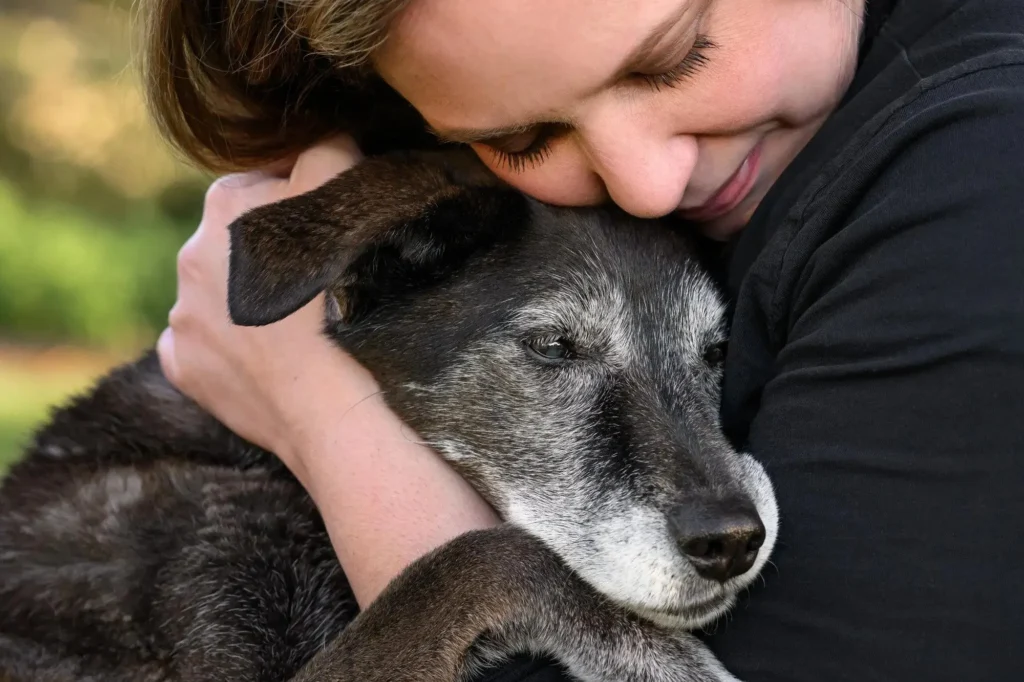 perro senior abrazado a su dueña
